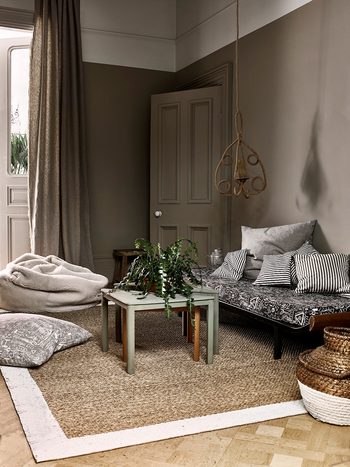 Salón con pared en Wall Paint French Linen, Old White y tejidos Linen Union y Tacit Ticking de Annie Sloan