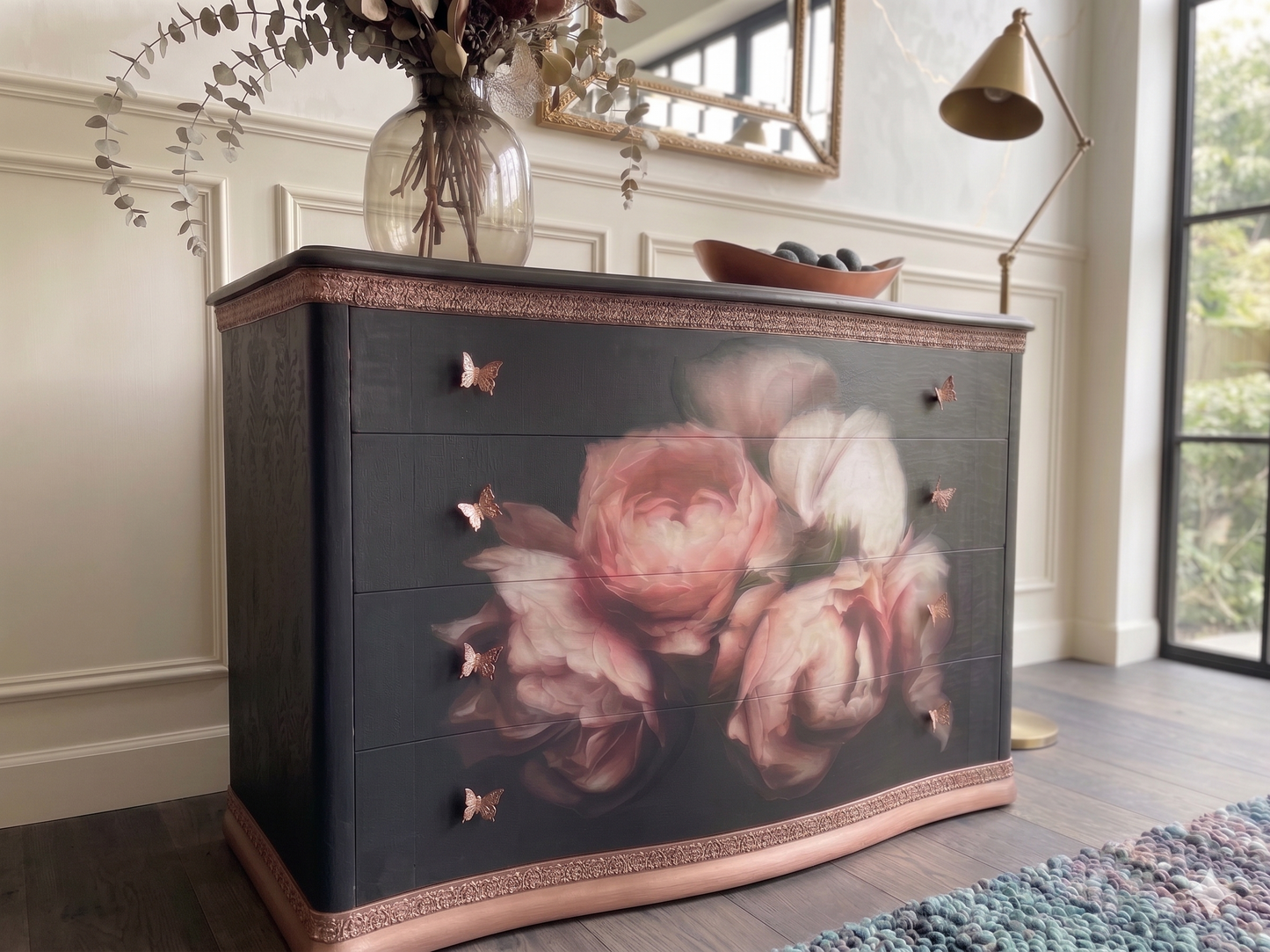 Cómoda vintage restaurada con rosas 3D en tonos rosas y blancos sobre fondo burdeos