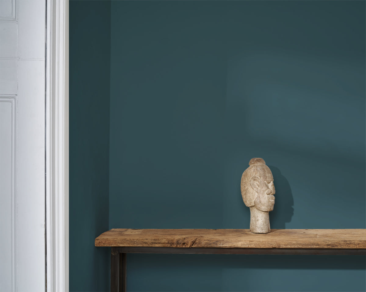 Pared pintada en Aubusson Blue con Wall Paint de Annie Sloan, junto a una escultura de cabeza decorativa