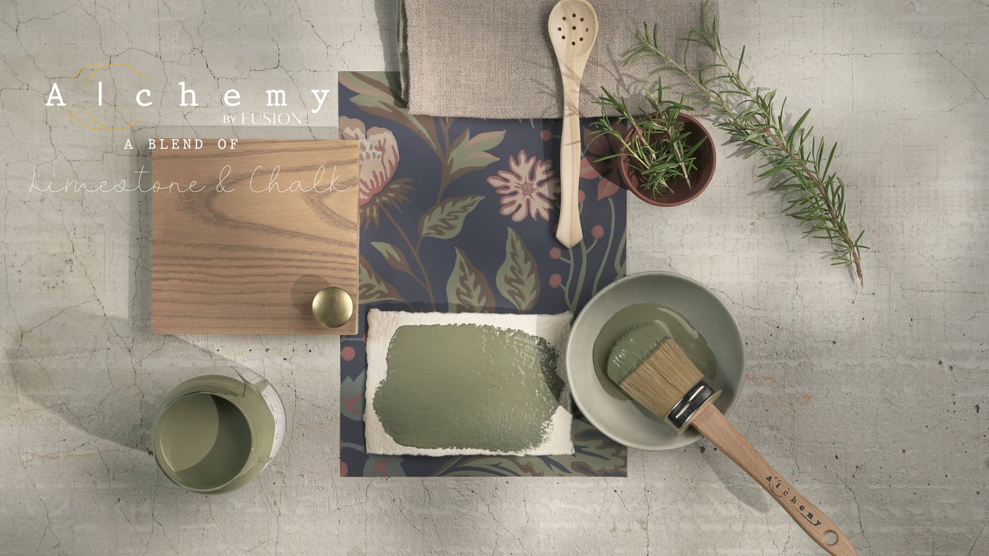 Flatlay inspiracional Alchemy by Fusion Rosemary con muestra de color verde herbáceo, bote abierto, brocha redonda, tirador dorado, papel botánico y rama de romero fresco sobre fondo de azulejo craquelado