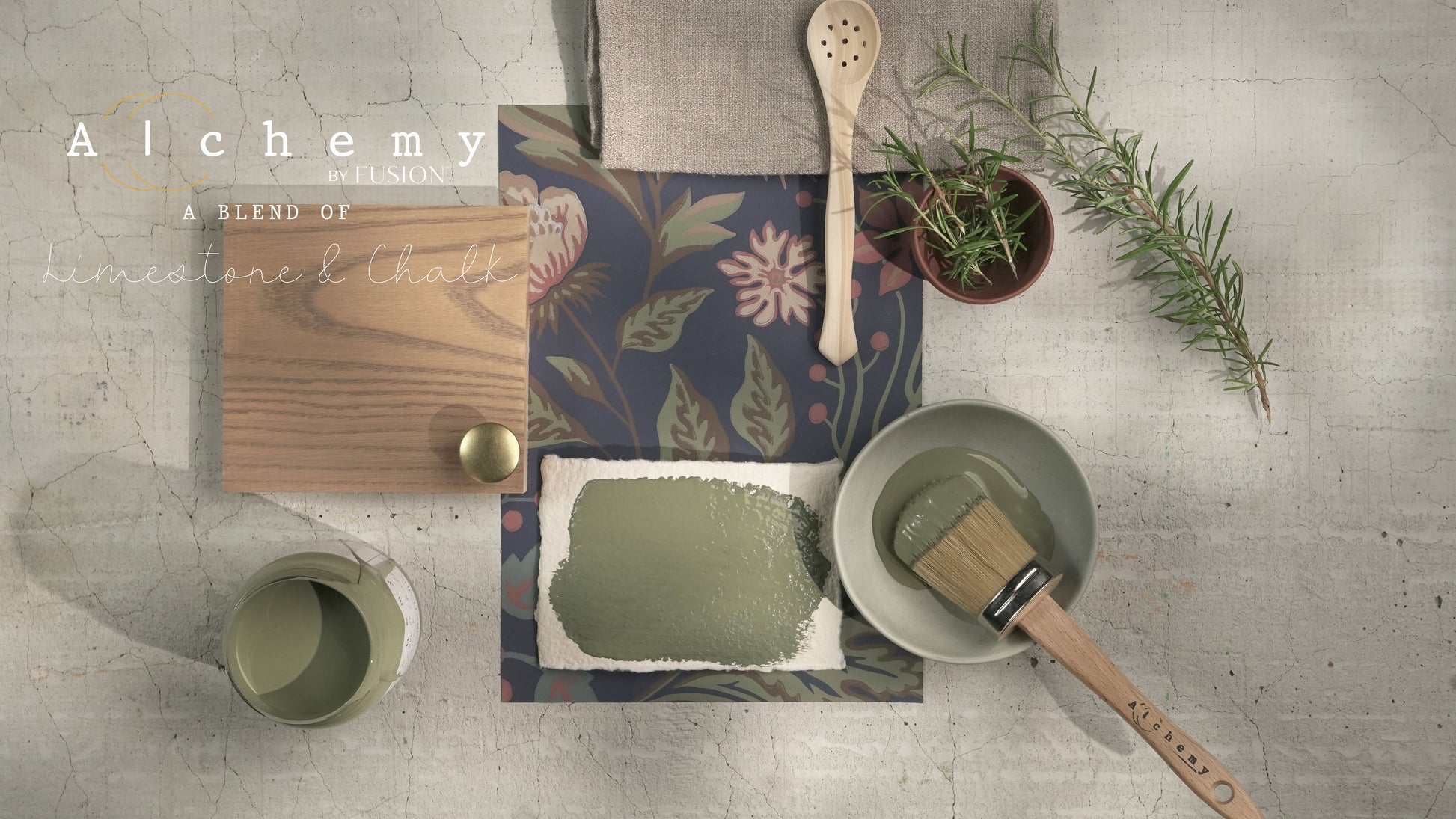 Flatlay inspiracional Alchemy by Fusion Rosemary con muestra de color verde herbáceo, bote abierto, brocha redonda, tirador dorado, papel botánico y rama de romero fresco sobre fondo de azulejo craquelado