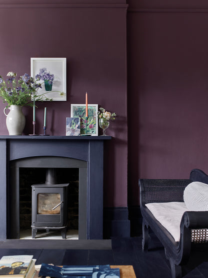 Salón decorado con paredes en Wall Paint Tyrian Plum y detalles en Satin Paint Oxford Navy de Annie Sloan