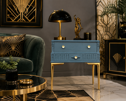 Mesita auxiliar vintage restaurada en azul profundo con patas doradas, estilo Art Déco, en salón elegante con lámpara de hongo negra