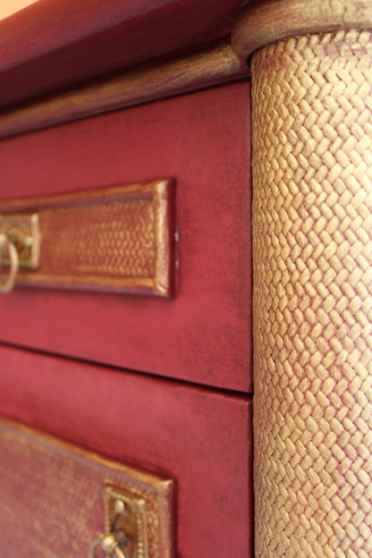 Detalle del cajón burdeos y de la columna con textura trenzada y acabado dorado envejecido de una mesita restaurada a mano.