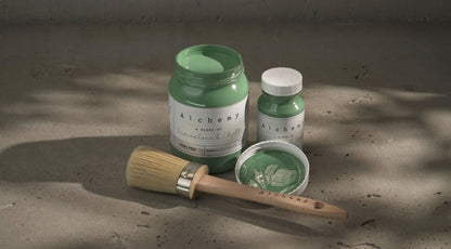 Botes Alchemy by Fusion Juniper 500ml y 120ml con brocha sobre superficie de cemento, pintura a la tiza verde medio con subtonos azules

