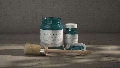 Botes Alchemy by Fusion Lagoon 500ml y 120ml con brocha sobre superficie de cemento, pintura a la tiza verde azulado teal