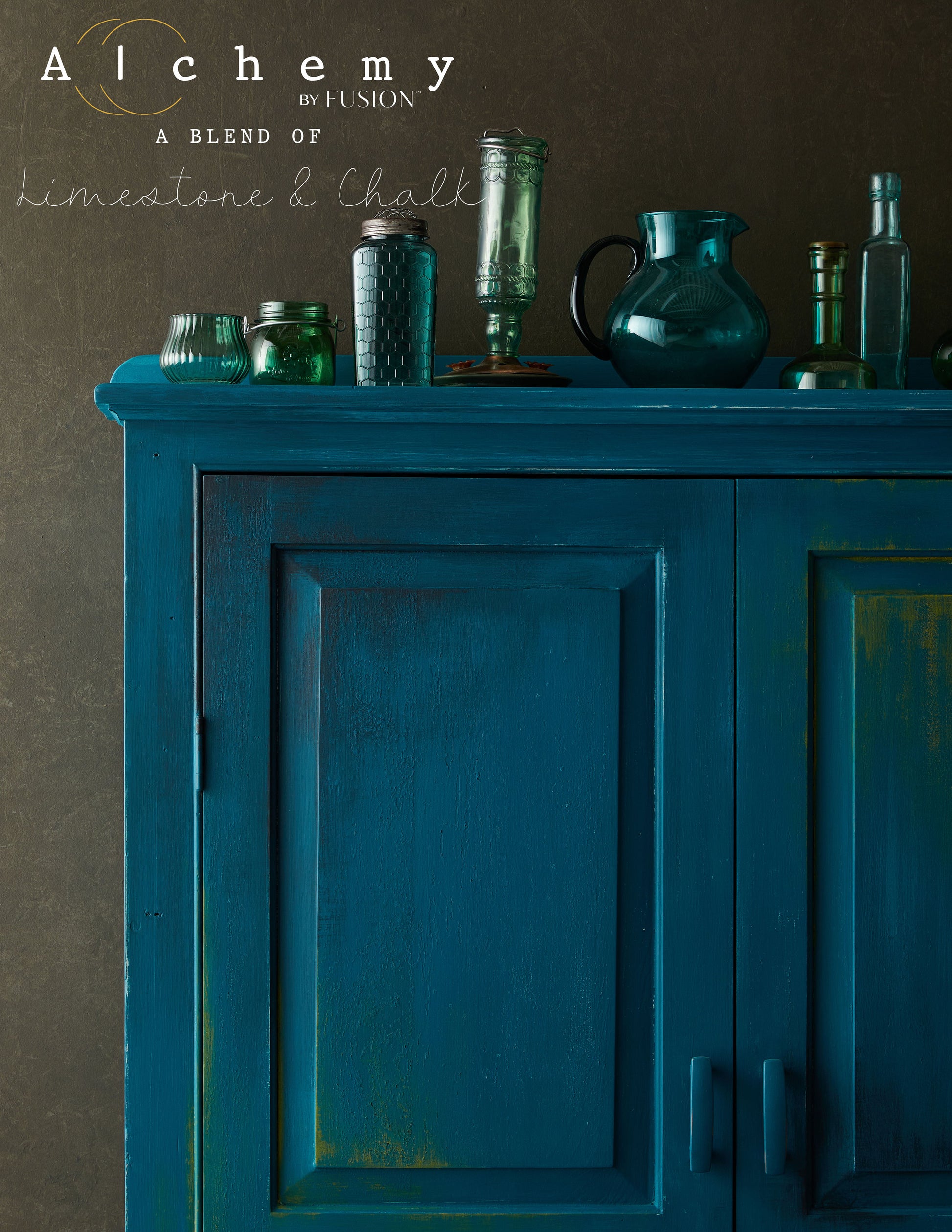 Detalle superior de armario restaurado con Alchemy by Fusion Lagoon en teal profundo, decorado con botellas y jarras de cristal verde, pintura limestone y chalk