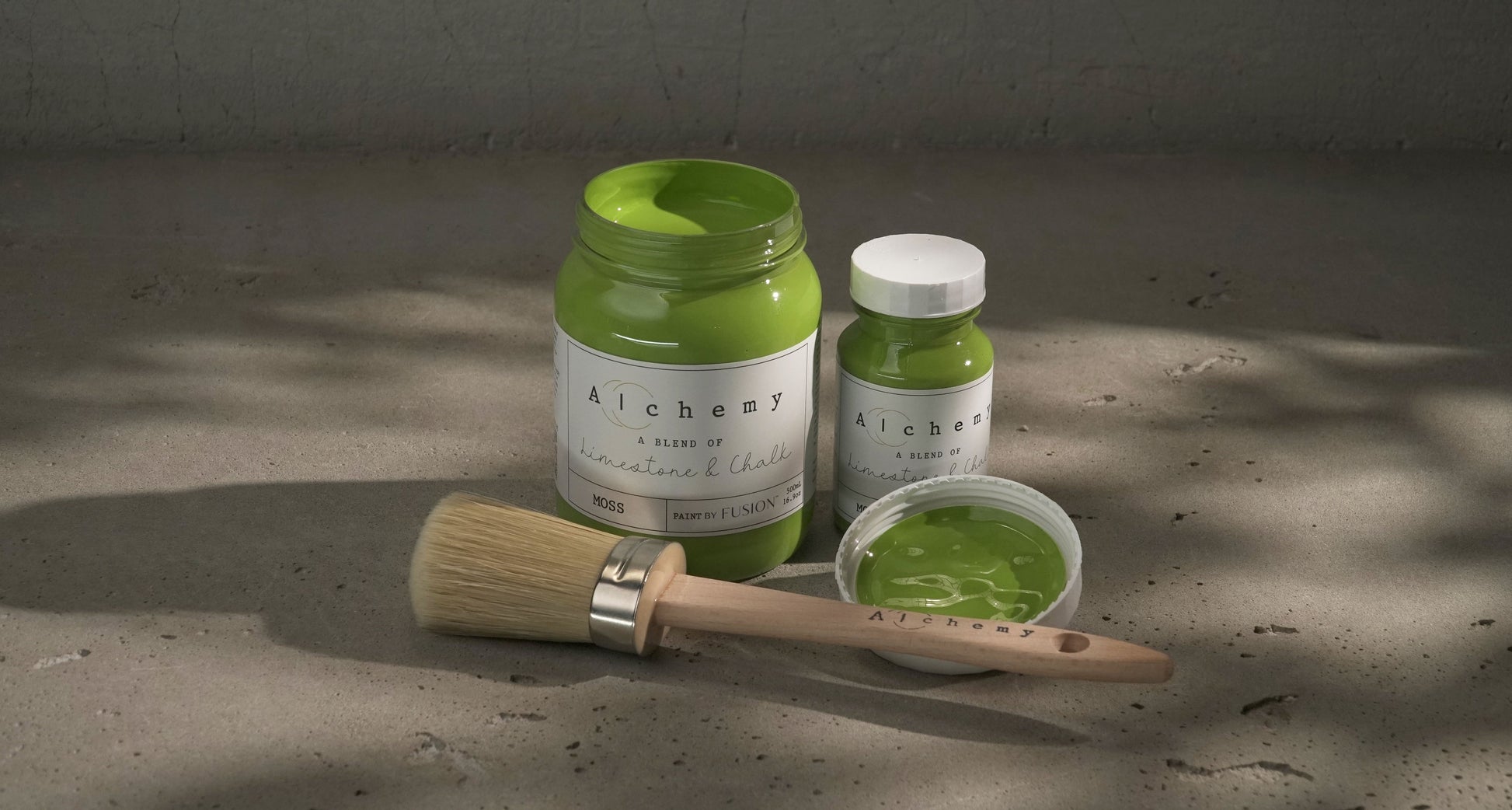 Botes Alchemy by Fusion Moss 500ml y 120ml con brocha sobre superficie de cemento, pintura a la tiza chartreuse verde amarillento vibrante