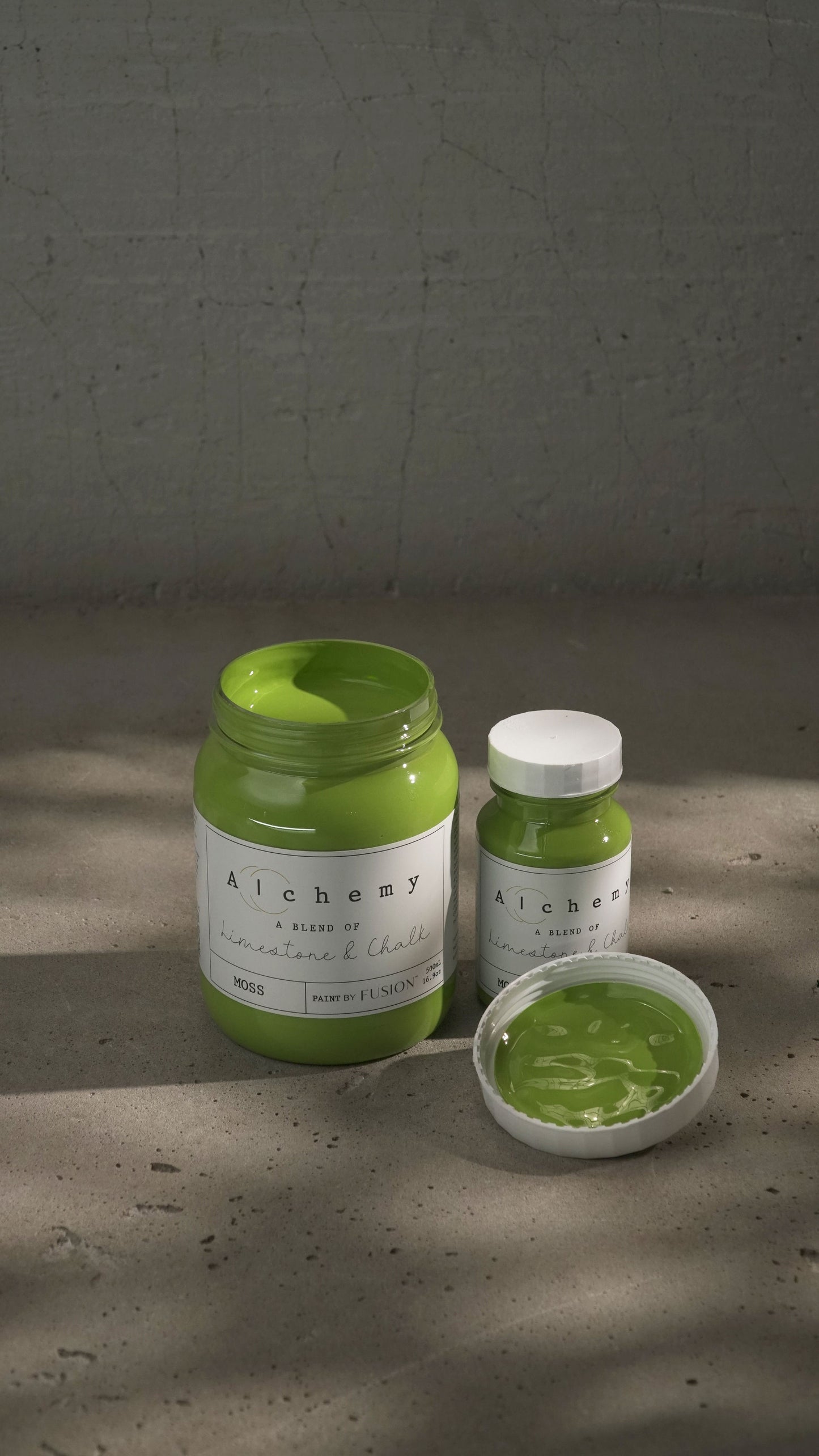 Botes Alchemy by Fusion Moss 500ml y 120ml con brocha sobre superficie de cemento, pintura a la tiza chartreuse verde amarillento vibrante