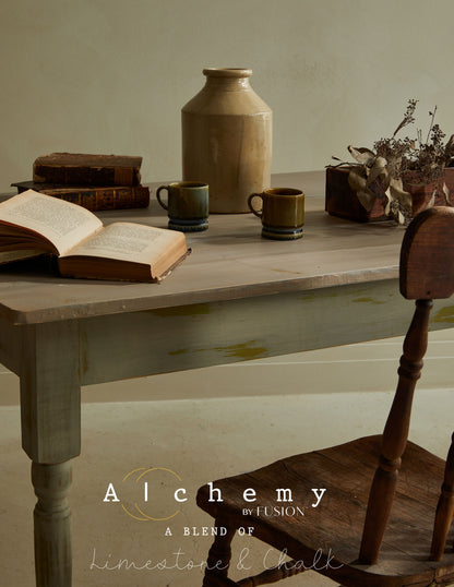 Detalle de mesa vintage restaurada con Alchemy by Fusion Sage en verde salvia con efecto envejecido, decorada con libros, jarra cerámica y tazas artesanales, pintura limestone y chalk