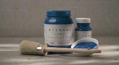 Botes Alchemy by Fusion Ocean 500ml y 120ml con brocha sobre superficie de cemento, pintura a la tiza azul marino intenso