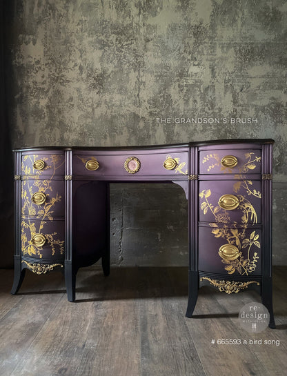 Transferencia Gold Foil A Bird Song Kacha en escritorio morado oscuro estilo Regency restaurado - pájaros y botanicals dorados en cajones y laterales - Re-Design with Prima - ambassador The Grandson's Brush
