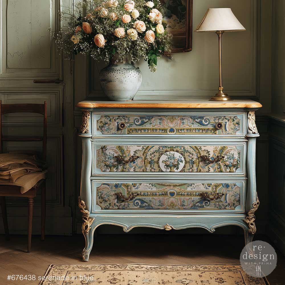 Papel decoupage Serenade In Blue de Re-Design with Prima aplicado en cómoda francesa azul celeste con tapa de madera natural y patas doradas - motivos barrocos con volutas y flores en cajones - estilo Versailles restaurado
