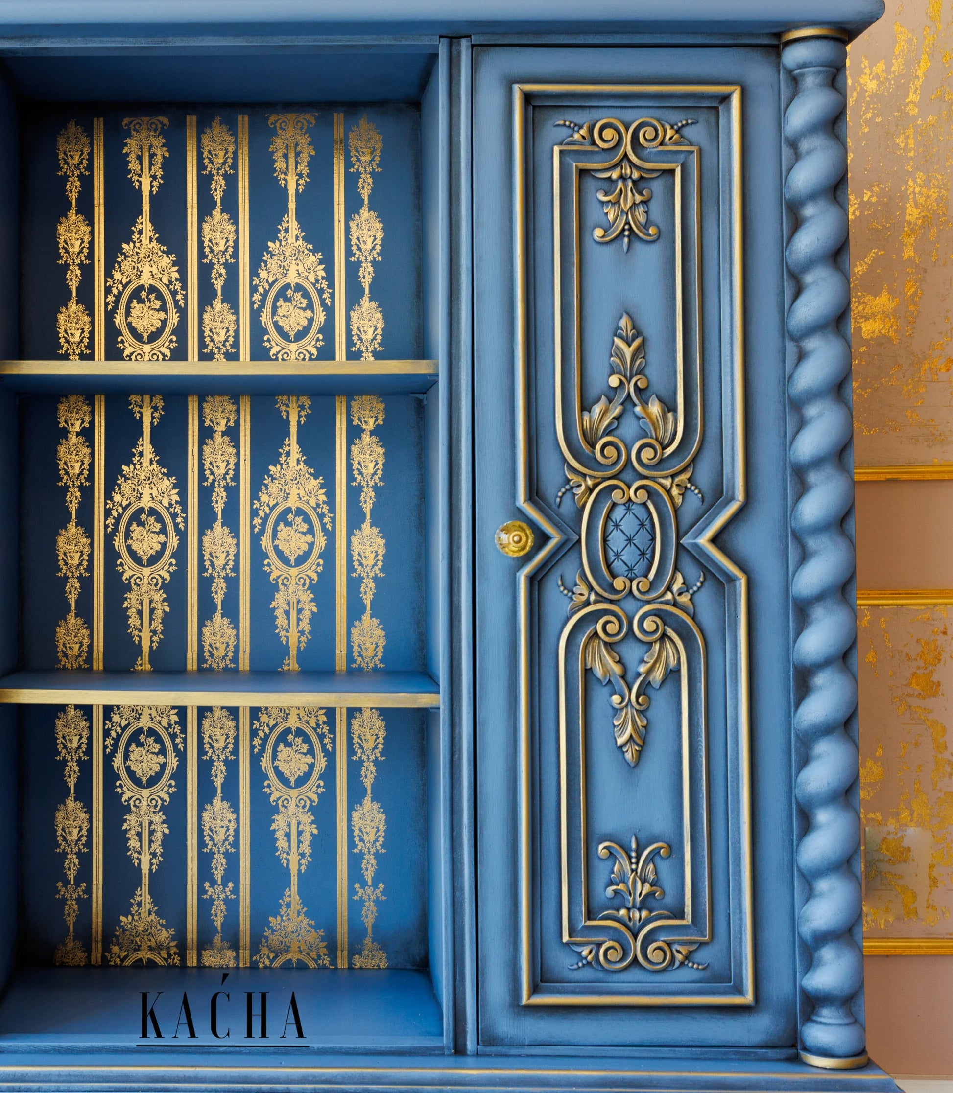 Detalle frontal de transferencia Gold Foil Chateau Filigree Kacha en vitrina azul cobalto abierta - filigranas y medallones dorados en interior con estantes, puertas con ornamentos barrocos dorados - Re-Design with Prima

